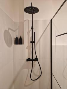 een douche in een badkamer met een zwarte douchekop bij Vaaz Rooms in Sannicandro di Bari