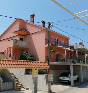 a pink house with a car parked in front of it at Miran in Ivanica