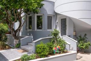 una casa con una escalera con plantas y un árbol en Junita's house, en Atenas