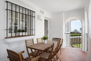 a dining room with a table and chairs and a window at Barrosa Primera línea de playa in Chiclana de la Frontera