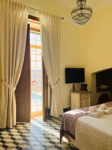Schlafzimmer mit einem Bett, einem TV und einem Fenster in der Unterkunft Cuba Real in Cuba