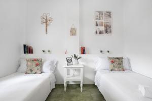 two beds in a white room with a table at Barrosa Primera línea de playa in Chiclana de la Frontera +20 photos