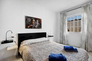 a bedroom with a bed with two blue pillows on it at Dúplex Chanca in El Puerto de Santa María