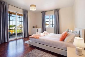een slaapkamer met een bed met kussens en ramen bij Apartamento Maria in Canhas