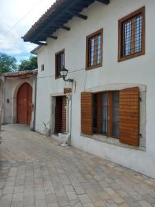 Casa blanca con puertas de madera y patio en Rooms for Rent, en Shkodër