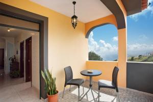 een patio met stoelen en een tafel op een balkon bij Apartamento Maria in Canhas