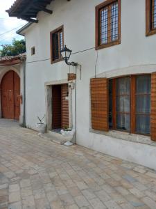 a white house with a door and a courtyard at Rooms for Rent in Shkodër