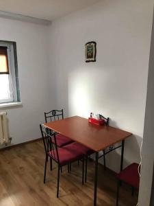 a dining room table with two chairs and a red box on it at Locatie buna la 2-3 min de plaja in Mangalia