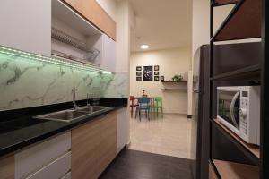 a kitchen with a sink and a microwave at Deluxe apartment with balcony, pool, fitness and yoga in Ho Chi Minh City