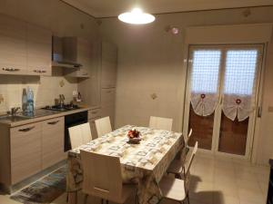 a kitchen with a table with chairs and a table and a table at La Perla dei Templi in Agrigento