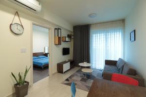 a living room with a couch and a table at Deluxe apartment with balcony, pool, fitness and yoga in Ho Chi Minh City