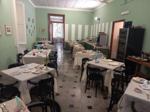 a dining room with tables and chairs with white table cloth at Hotel Miramare in Lavagna