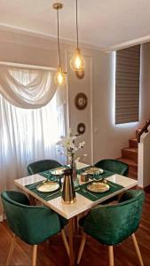 une salle à manger avec une table et des chaises vertes dans l'établissement Aleena's Guesthouse BSD City, à Tangerang