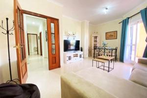 sala de estar con sofá y TV en Apartamento Camaleón, en Chipiona