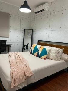 当格浪Aleena's Guesthouse BSD City的卧室里有一张白色的床，上面放着枕头