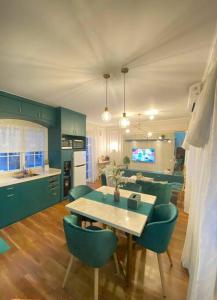 a kitchen with a table and some green chairs at Aleena's Guesthouse BSD City in Tangerang