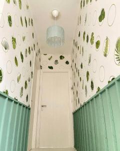 a hallway with a door and a plant wall at Aleena's Guesthouse BSD City in Tangerang