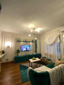 a living room with a couch and a flat screen tv at Aleena's Guesthouse BSD City in Tangerang