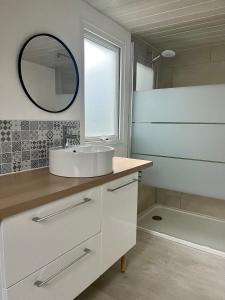 a bathroom with a sink and a mirror and a tub at Camping Le Calypso 5 étoiles in Torreilles