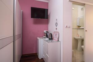 bagno con parete rosa e lavandino di Vikeli a Trogir