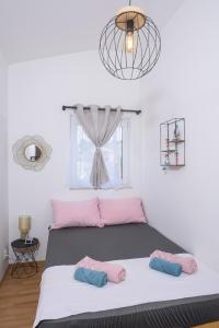 una camera da letto con un letto con cuscini rosa e blu di Vikeli a Trogir