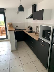a kitchen with black cabinets and a counter top at Nouveauté Sunset appart vue exceptionelle in Saint-Denis