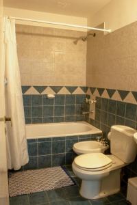 y baño con aseo, bañera y lavamanos. en DEPARTAMENTO Nº7 COMPLEJO PRIVADO en Godoy Cruz