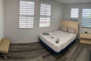 a bedroom with a large bed and two windows at 18 Bedrooms 32 guest max San Juan Puerto Rico in San Juan
