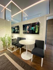 een vergaderruimte met een tafel en stoelen en 2 monitoren bij New Lux Business Apartment in the Center in Chişinău