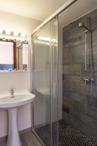 a bathroom with a sink and a glass shower at Apartamentos Wundermar in Torredembarra