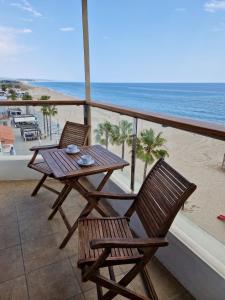a table and chairs on a balcony with the beach at Apartamentos Wundermar in Torredembarra