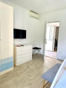 Habitación blanca con TV y vestidor con una bañera de hidromasaje en Villa Mare & Filip 2 en Zaton