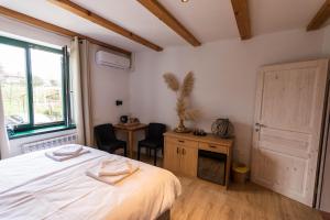 um quarto com uma cama, uma secretária e uma janela em Rooms&Vinery Bregovi - Sobe in vinska klet Bregovi em Dobravlje