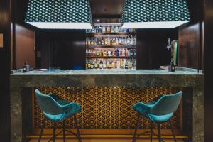 a bar with two blue bar stools in a room at Hotel Taburiente S.C.Tenerife in Santa Cruz de Tenerife