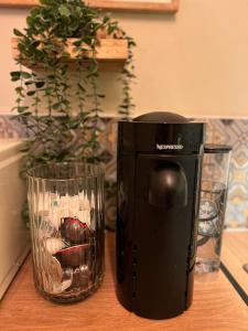 a black coffee maker sitting on a table next to a glass at Beautiful flat sleeps 4 in Taplow Maidenhead Near Windsor and Ascot racecourses Near Legoland in Taplow