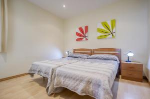 1 dormitorio con 1 cama y una pintura en la pared en Gregal Atico Roses - Immo Barneda, en Roses