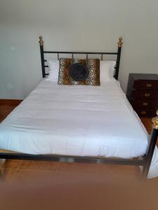 a bed with a black frame with a camera on it at Beach,surf, hiking and more in Maceira
