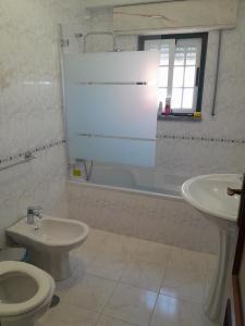 a bathroom with a toilet and a sink and a tub at Beach,surf, hiking and more in Maceira