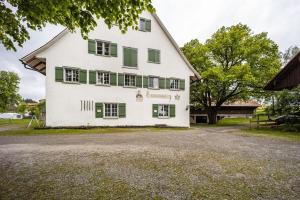 an old white house with green shutters at Klosterhof Eggenreute in Wangen im Allgäu