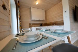 een keuken met een tafel met borden erop bij Solano Apartments in Stepnica