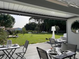 een terras met tafels en stoelen bij Le 36 Maison d'hôtes Piscine & Spa in La Flotte