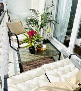 a balcony with a couch and a table with plants at Proche Château de Versailles avec balcon vu sur une forêt et parking gratuit pour 5 personnes maximum in Versailles