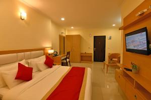 um quarto de hotel com uma cama grande com almofadas vermelhas em Clarks Residences, Nainital em Nainital