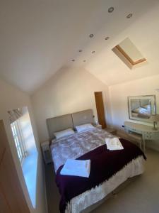 a bedroom with a bed and a sink and a mirror at Holly Cottage in Gringley on the Hill