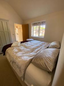 ein großes Bett in einem Schlafzimmer mit Fenster in der Unterkunft Holly Cottage in Gringley on the Hill