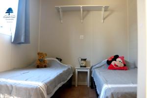dois ursos de peluche sentados em camas num quarto em Mobilhome Sensation Vacances em Sigean