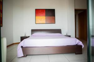 1 dormitorio con 1 cama y una pintura en la pared en CASA VACANZA ARAMARE 22, en Civitanova Marche
