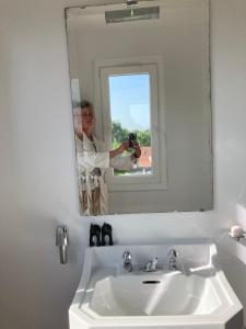 a woman taking a picture of herself in a bathroom mirror at La suite de la Villa Plume 