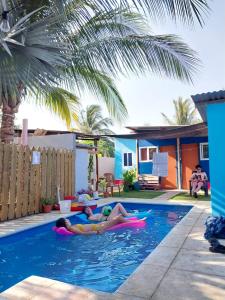 2 personnes se posant sur des gonflables dans une piscine dans l'établissement Bedrooms where Charlie, à El Paredón Buena Vista