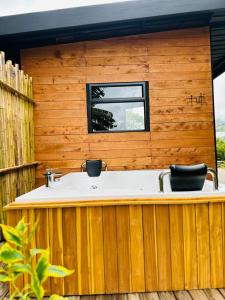 a bath tub in a wooden building with a window at Rainbow Glamping in Abejorral